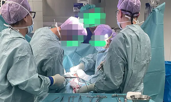 Chirurgisches Team führt einen Eingriff durch, umgeben von medizinischen Instrumenten auf dem Tisch.